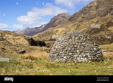 A domed Stone Cairn within the imposing mountains of Glen Coe in the Scottish Highlands Stock ...