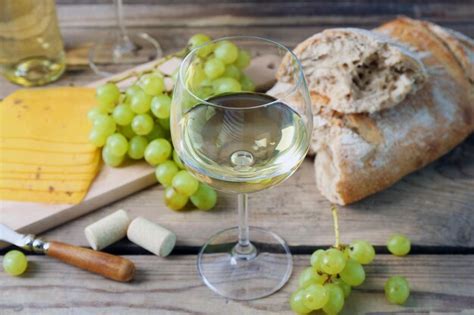 Bodegón de queso de uva de vino y pan sobre fondo de madera rústica