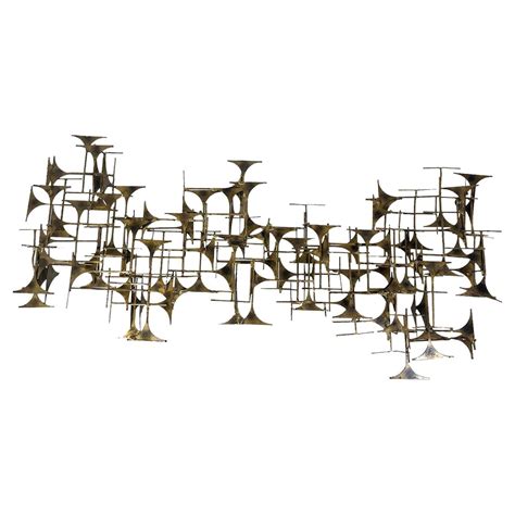 A vintage 1960's metal wall sculpture with gilded accents at 1stDibs