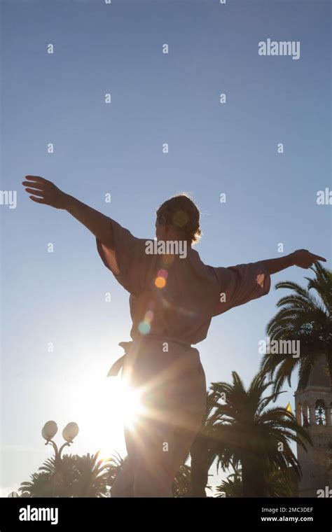 Beautiful Young Woman Raising Arms Under Blue Sky Concept Of Freedom