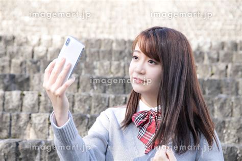 スマホで自撮りする日本人女子高校生の写真素材 [163995809] イメージマート