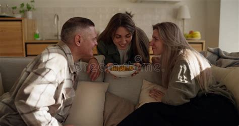 Happy Brunette Girl Prepared Cookies And Her Mature Parents Sitting On