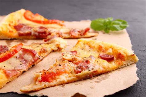 Pizza With Sausage Ham Tomato And Cheese Decorated With Basil And