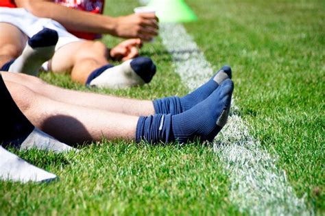Premium Photo Low Section Of Athletes Wearing Socks While Sitting On
