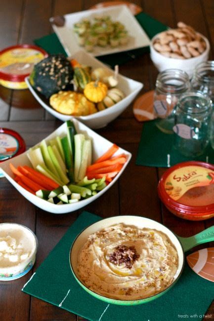 A Table Topped With Bowls Filled With Dips And Veggies Next To Other Food