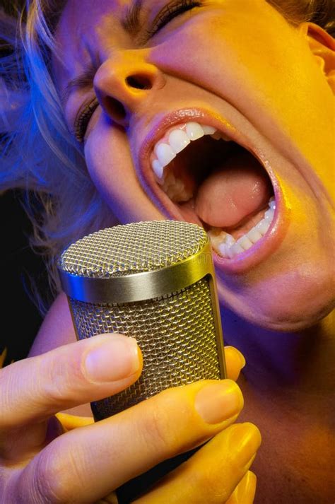 Passionate Gemale Vocalist Under Gelled Lighting Sings With Open Mouth