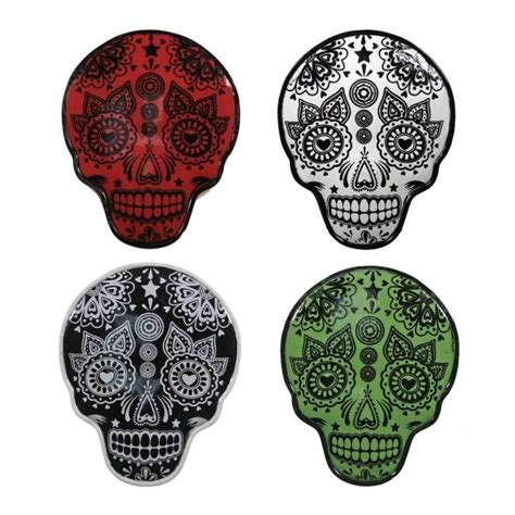 Four Different Colored Sugar Skulls On White Background