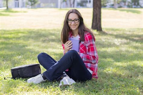 Premium Photo Woman Sitting On The Grass And Reading Book