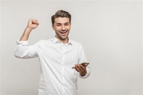 Homem Feliz Segurando O Celular Agitando Os Punhos Comemorando O