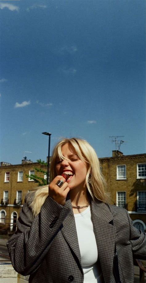 A Woman Standing In Front Of A Building With Her Mouth Open