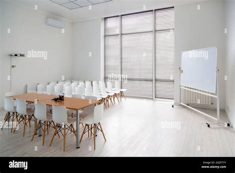 Meeting room with a large white school board and white chairs in modern office Stock Photo - Alamy