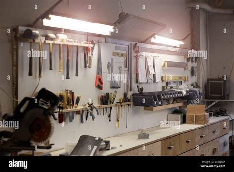 Image Of Workshop With Work Place And Work Tools Hanging On The Wall