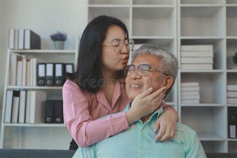 A Father And Daughter Sat In The Living Room Happily Spending Time