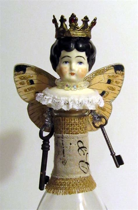 A Glass Bottle With An Angel Figure In It And A Key Hanging From The Top