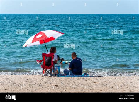 Canadian People With Umbrella At The Beachfront Park In The City Of