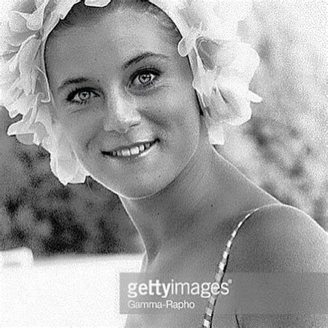 A Woman With A Flower In Her Hair Smiles At The Camera Black And White