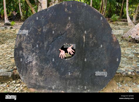 Stone money (Rai stones) in the bank, hands extending from the hole in ...