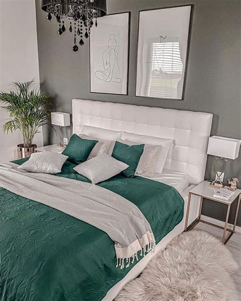 A Bed With Green And White Comforter In A Bedroom Next To Two Pictures