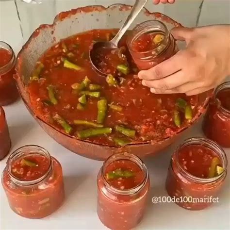 A Person Is Dipping Sauce Into Jars With Spoons