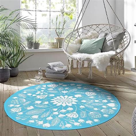 A Blue And White Circular Rug In A Room With Potted Plants On The Floor