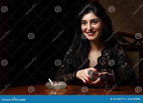 Une Belle Brunette Aux Lèvres écarlates En Vêtements Noirs S installe à