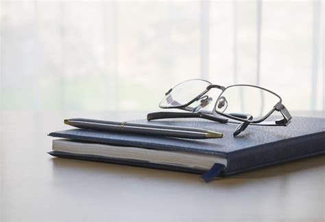 Glasses And Pen On A Book Premium Photo