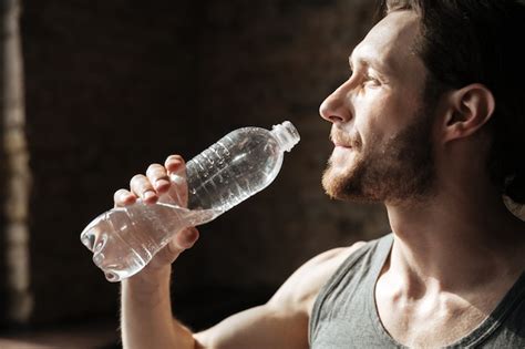 Сильный спортсмен в спортзале питьевой воды. | Бесплатно Фото