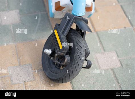 Close Up Of Broken Electric Scooter Front Wheel On Grey Asphalt