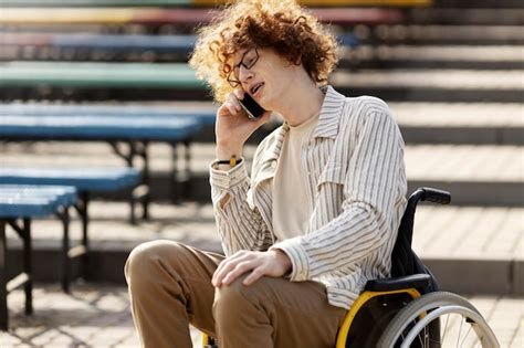 Premium Photo Curly Redhaired Guy In Glasses Sits In A Wheelchair And