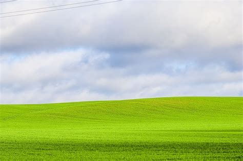 Campo de grama verde nas colinas e céu azul nuvens na paisagem