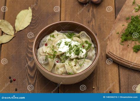 Bolas De Masa Hervida Rusas De La Carne Del Pelmeni Con Verdes En La