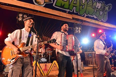 Two Men Are Playing An Accordion And Singing Into Microphones While