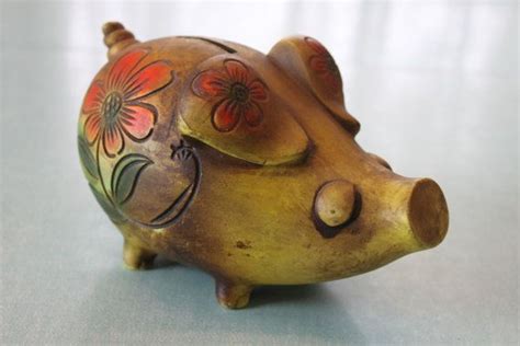 A Ceramic Pig Figurine With Flowers Painted On It