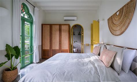 A Bedroom With A Large Bed And Green Doors On The Wall Behind It Along