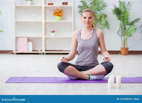 La Mujer Joven En La Actitud Del Loto Que Medita En Gimnasio Del