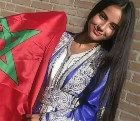 A Woman Holding A Flag In Front Of A Brick Wall