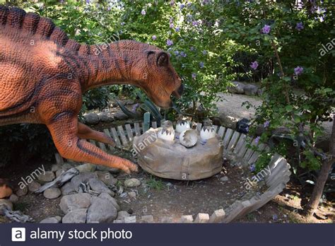 Dinosaur statue in the forest park in nature for background. Realistic model of Dinosaur near ...