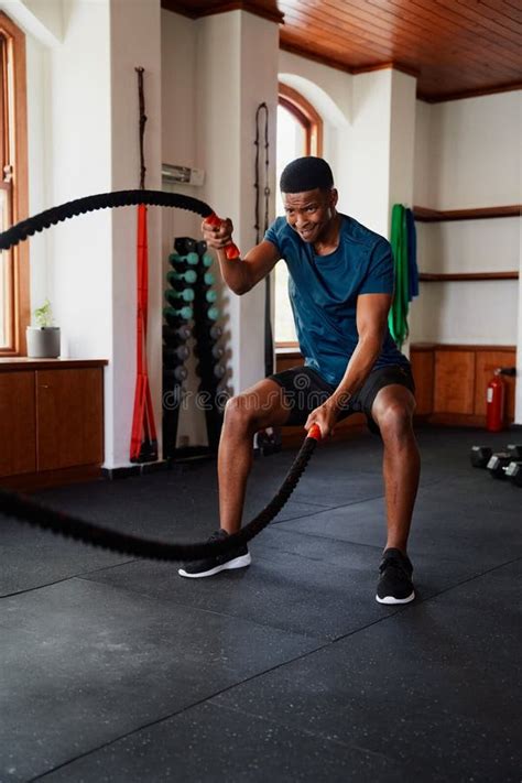 Determined Young Black Man Doing Workout with Battle Ropes at the Gym ...