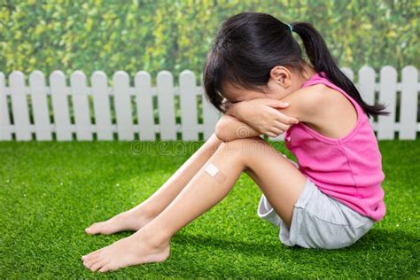 Petite Fille Chinoise Asiatique S Asseyant Sur L Herbe Et Pleurer Image