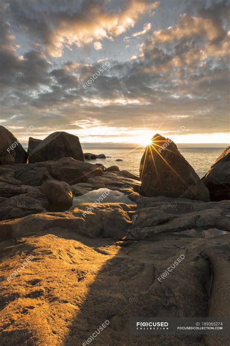 Rock formation by sea at sunset, Vasterbotten County — dusk, shadow ...