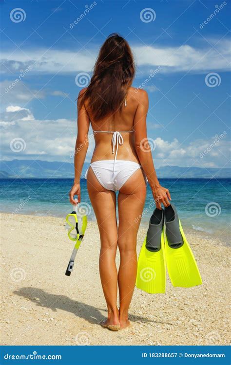 Jeune Femme Dans Le Bikini Debout Sur Une Plage Avec Tuba Et Des Palmes De Masque Image Stock