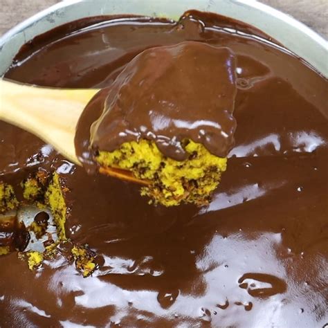 A Wooden Spoon Scooping Out Some Chocolate From A Pan Filled With