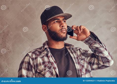 African American Bearded Man Wearing A Checkered Shirt And Cap Talking