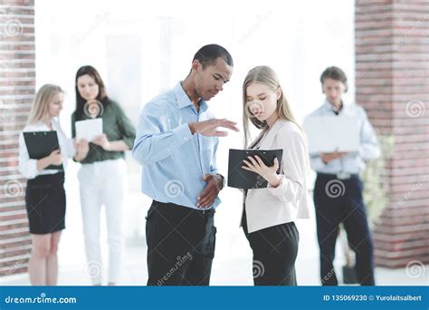 Employees Discussing Business Document Standing In The Office Stock