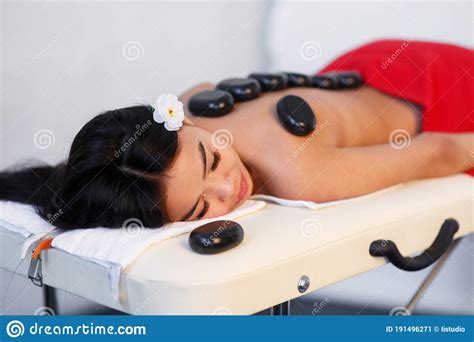 Woman Lying On Massage Table With Stones On Her Back At Spa Stock Image