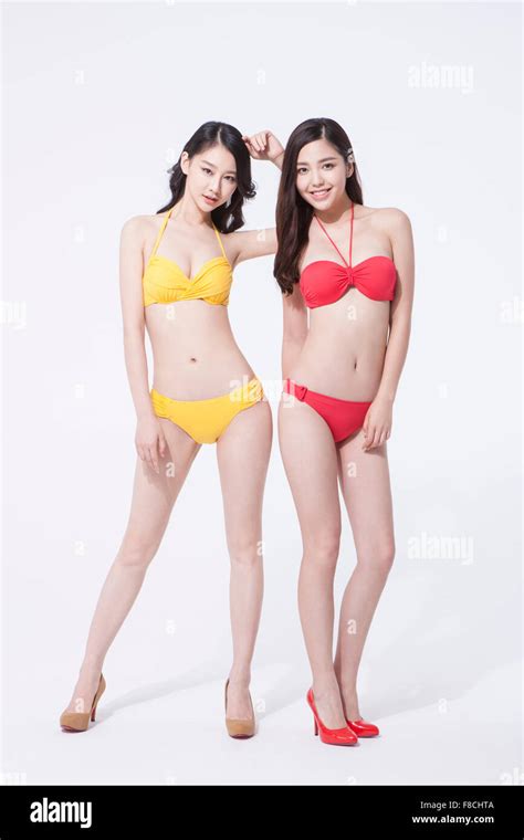 Femme en bikini jaune et des talons debout à côté d une femme en bikini rouge et talons rouges