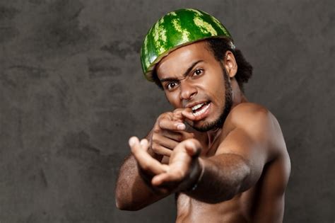 Free Photo African Man With Watermelon On Head Fooling Over Grey Wall