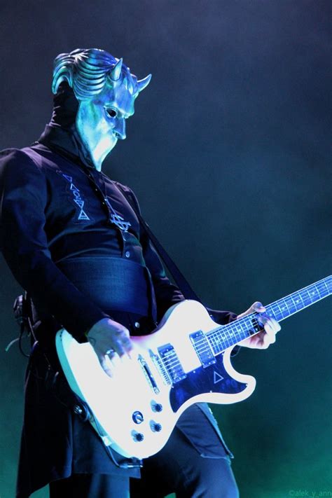 A Man With Blue Makeup Playing An Electric Guitar