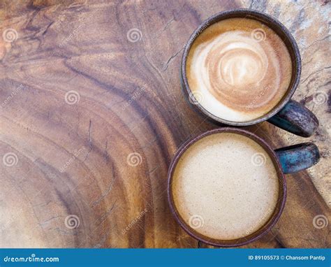 Two Cups Of Hot Coffee Cappuccino On Wood Texture Background To Stock