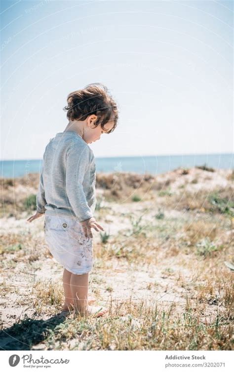 Barefoot child in short barefoot on sandy beach - a Royalty Free Stock ...